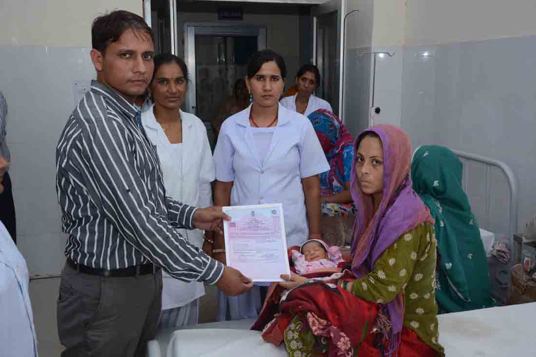 अस्पताल में जन्म प्रमाण पत्र देते हुए
